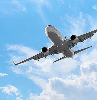 Aufnahme eines Flugzeugs von unten bei blauem Himmel